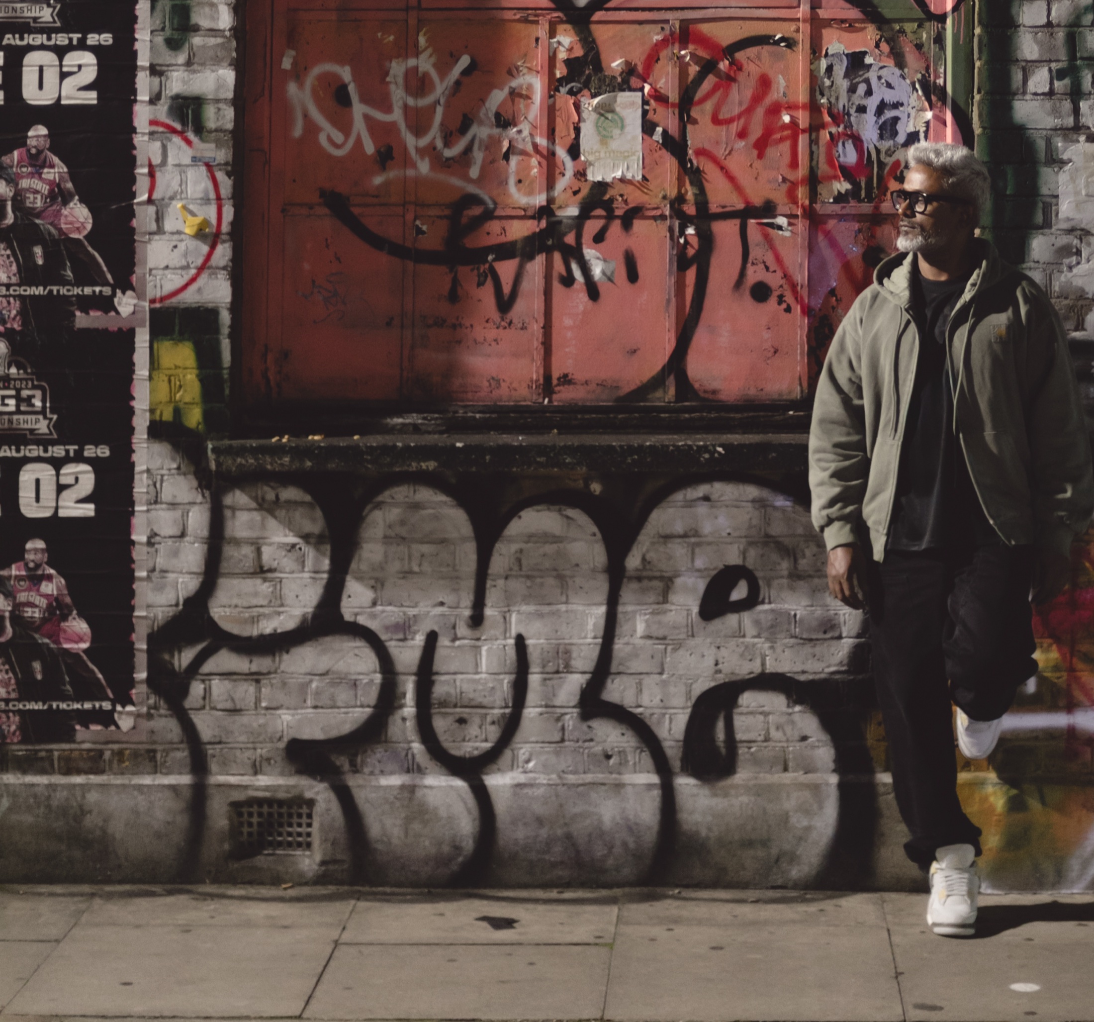 Murthovic, portrait against a graffiti wall