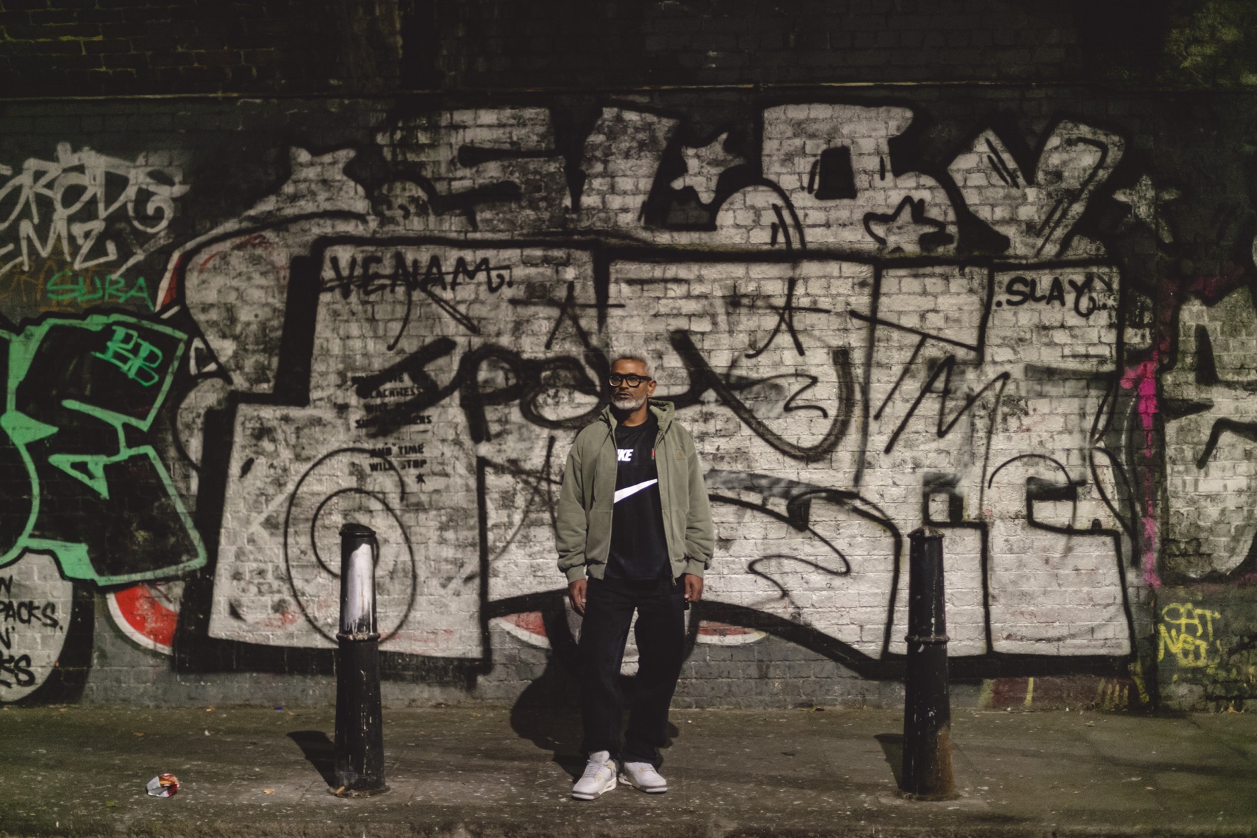 Murthovic, portrait against a graffiti wall